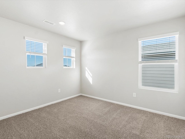 carpeted empty room featuring visible vents and baseboards