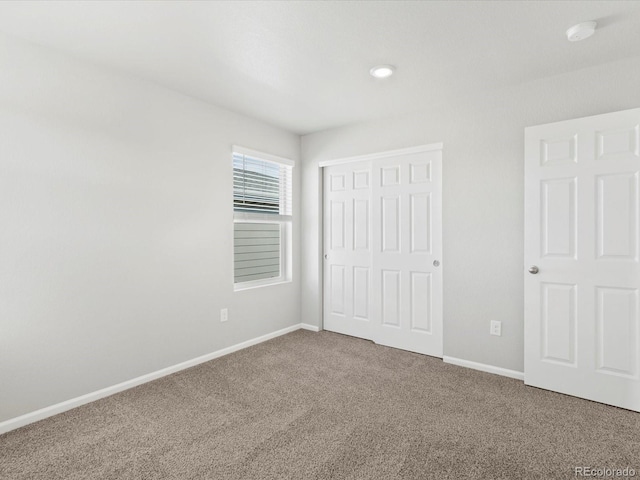 unfurnished bedroom featuring a closet, carpet flooring, and baseboards