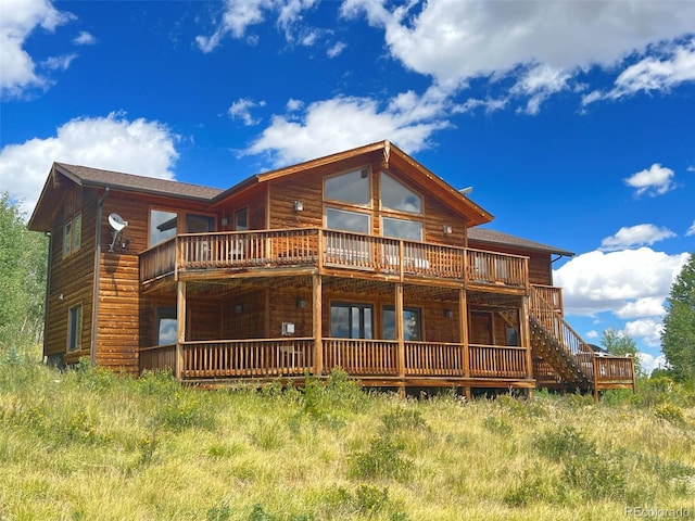 back of property with a deck and a balcony