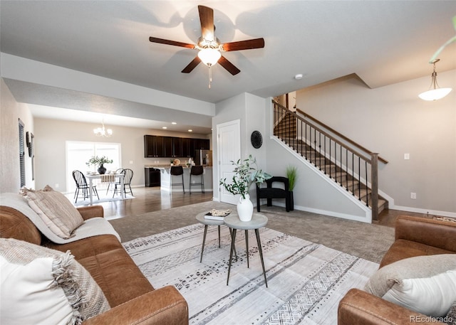 living room featuring ceiling fan with notable chandelier