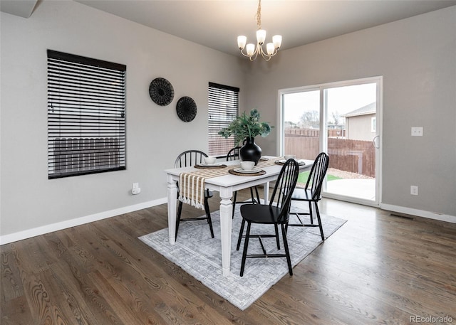 dining room featuring dark hardwood / wood-style flooring and an inviting chandelier