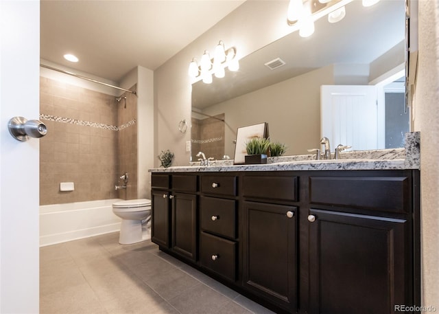 full bathroom featuring tile patterned flooring, vanity, toilet, and tiled shower / bath