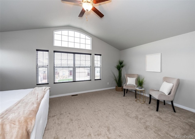 living area with ceiling fan, a healthy amount of sunlight, light colored carpet, and lofted ceiling