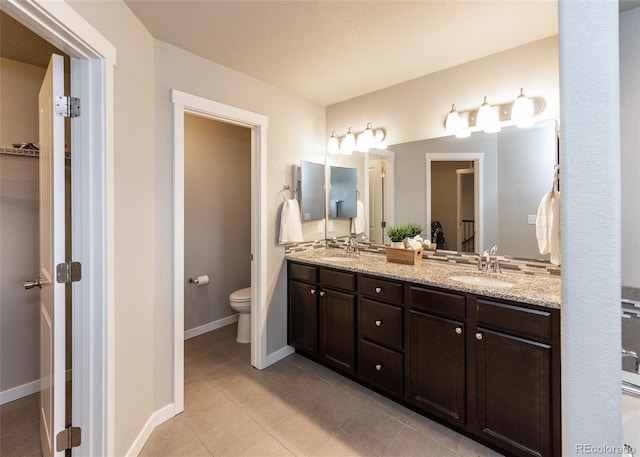 bathroom featuring tile patterned flooring, vanity, and toilet