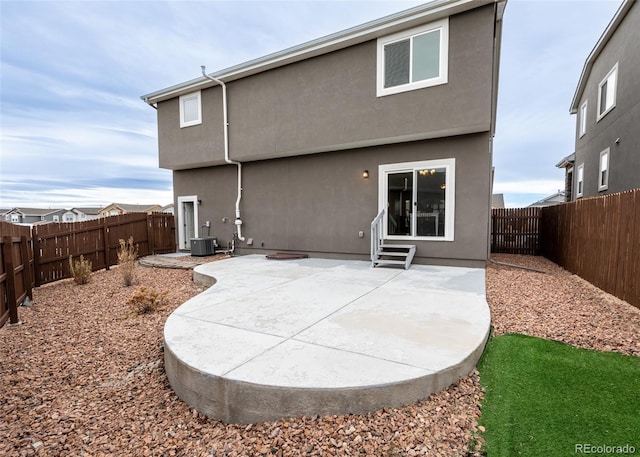 rear view of property featuring central AC unit and a patio area