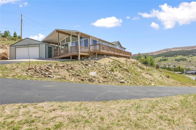 235 W May St, Cripple Creek, CO 80813 - view of front of property with a deck with mountain view, an outbuilding, asphalt driveway, and a detached garage