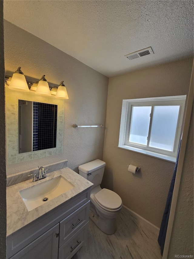 1265 S Biscay St, Aurora, CO 80017 - bathroom featuring vanity, a textured ceiling, a textured wall, and wood finished floors