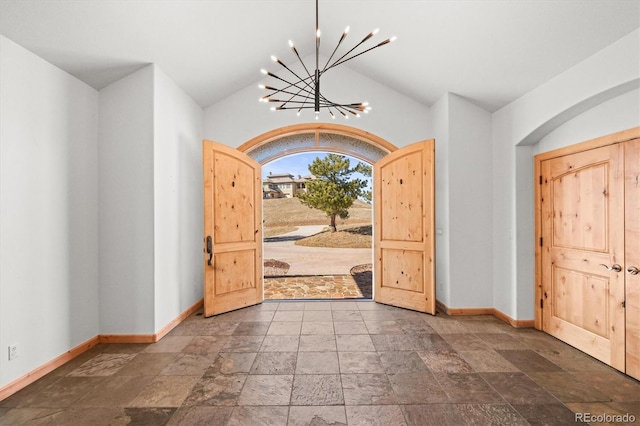 156 S Lookout Mountain Rd, Golden, CO 80401 - entrance foyer featuring baseboards, a chandelier, stone tile floors, arched walkways, and lofted ceiling