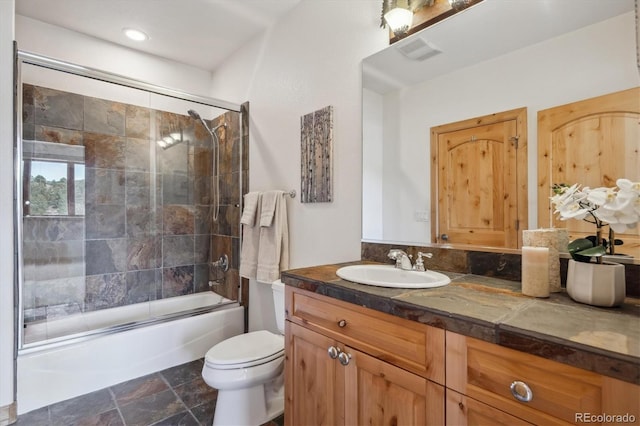 156 S Lookout Mountain Rd, Golden, CO 80401 - full bathroom featuring vanity, toilet, bath / shower combo with glass door, and stone finish flooring