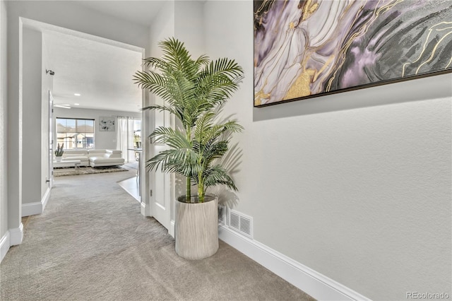 hallway featuring light colored carpet