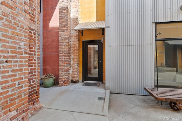 view of exterior entry with brick siding