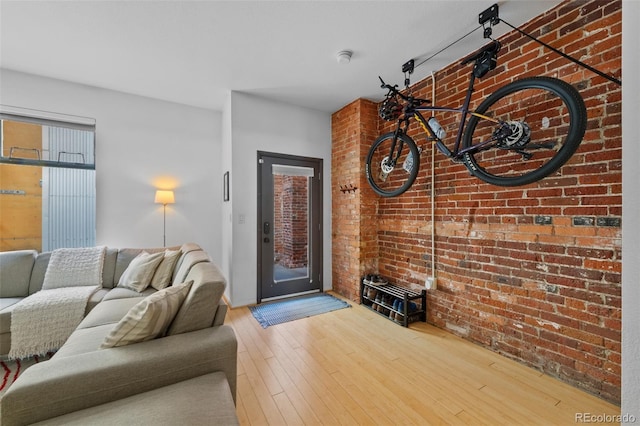 living room featuring brick wall and hardwood / wood-style flooring