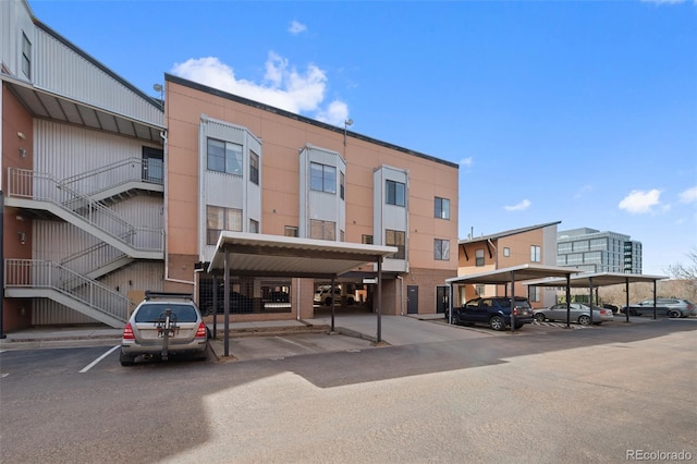 view of property featuring stairs and covered and uncovered parking