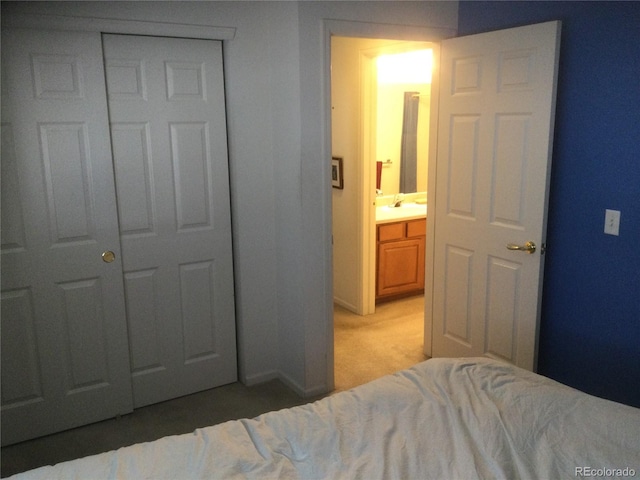 bedroom with ensuite bath, a closet, and carpet floors