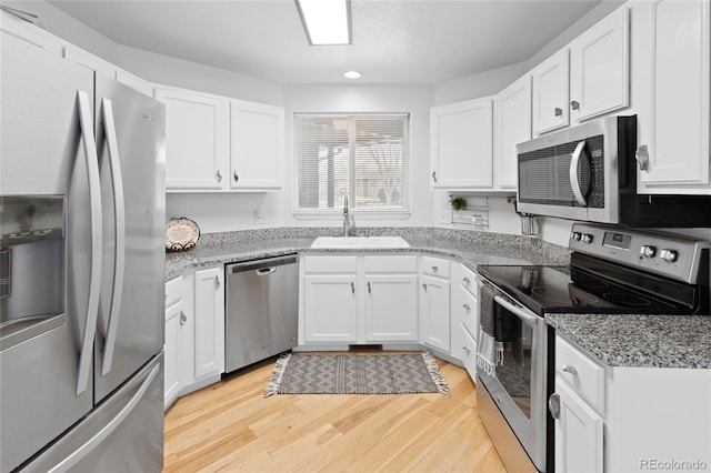 kitchen featuring white cabinets, stainless steel appliances, and light stone countertops