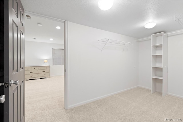 spacious closet featuring light carpet