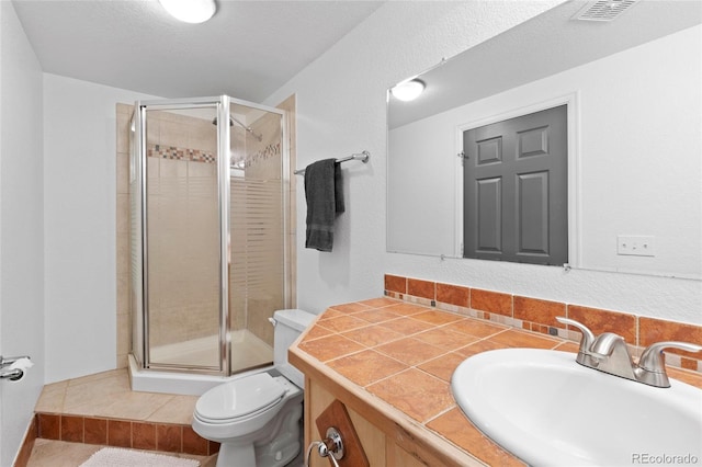 bathroom with an enclosed shower, vanity, toilet, and tile patterned floors