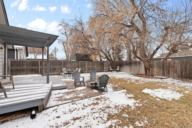 yard covered in snow with a pergola and a wooden deck