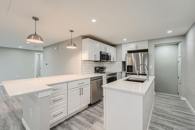 kitchen with sink, white cabinetry, hanging light fixtures, a center island with sink, and stainless steel appliances