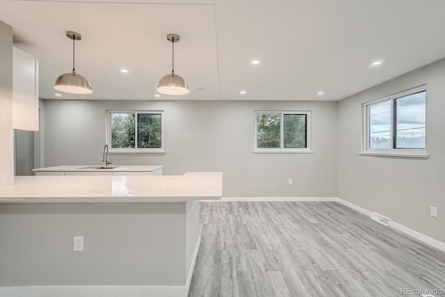 kitchen with sink, decorative light fixtures, and kitchen peninsula