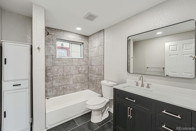 full bathroom featuring tile patterned flooring, vanity, tiled shower / bath, and toilet