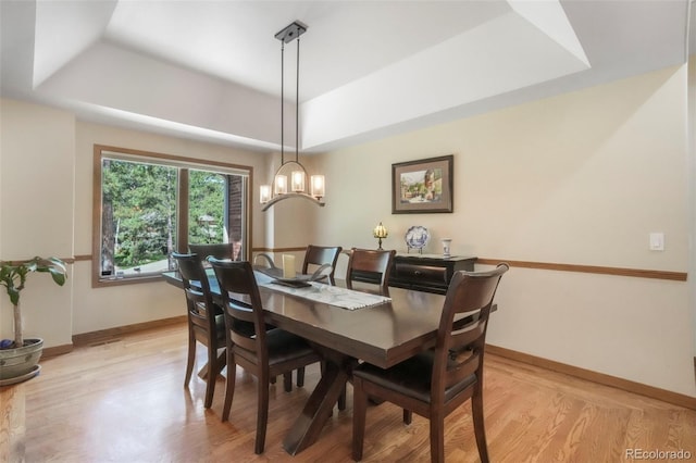 19165 Golden Arrow Cir, Monument, CO 80132 - dining space with a raised ceiling, light wood-type flooring, and a chandelier