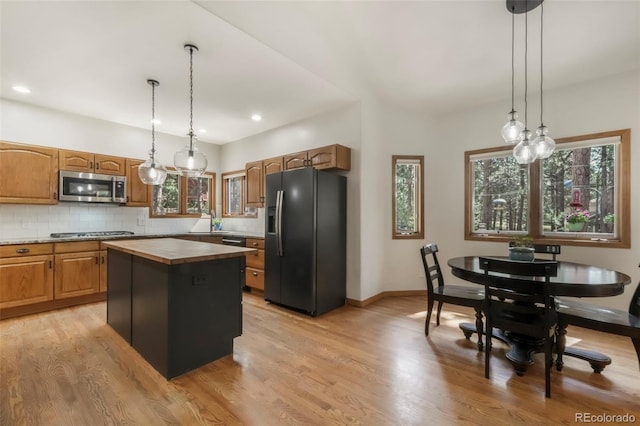 19165 Golden Arrow Cir, Monument, CO 80132 - kitchen with stainless steel microwave, black fridge, gas cooktop, healthy amount of natural light, and recessed lighting