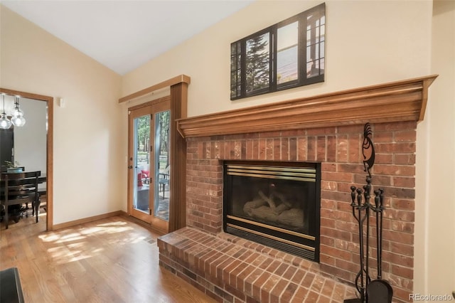 19165 Golden Arrow Cir, Monument, CO 80132 - unfurnished living room with lofted ceiling, wood finished floors, and a fireplace