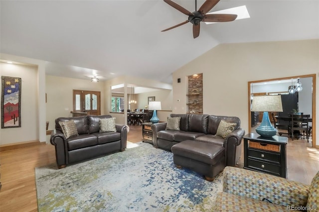 19165 Golden Arrow Cir, Monument, CO 80132 - living room with wood finished floors, a ceiling fan, vaulted ceiling, and a skylight