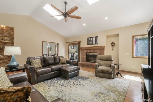19165 Golden Arrow Cir, Monument, CO 80132 - living area with a ceiling fan, lofted ceiling, light wood-style flooring, a fireplace, and a skylight