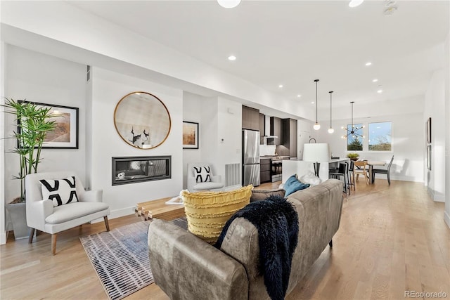 living room with a chandelier and light hardwood / wood-style flooring