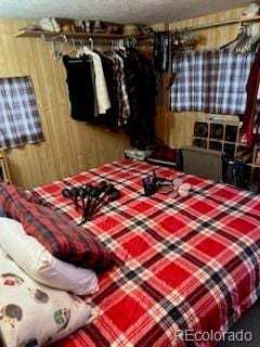 bedroom featuring wood walls