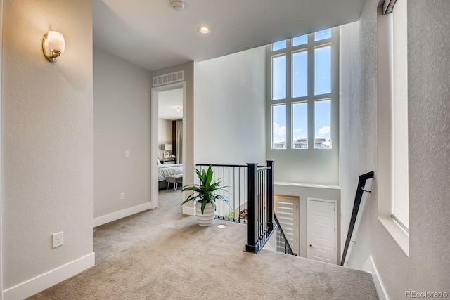 hall featuring light colored carpet