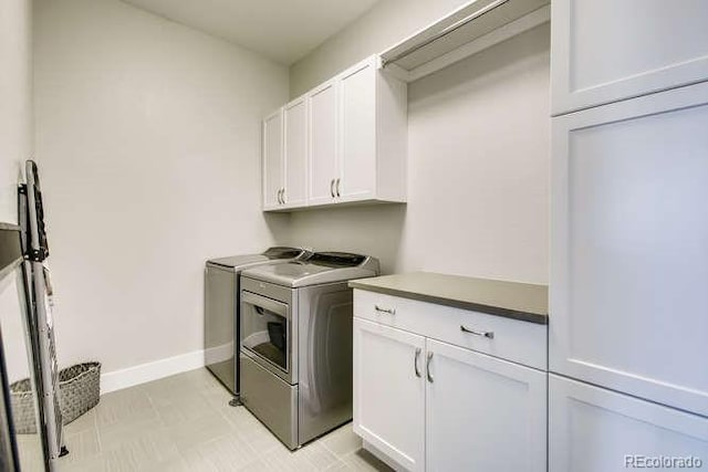 washroom featuring washing machine and dryer and cabinets