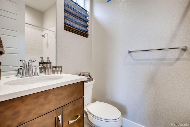 bathroom with a shower, vanity, and toilet