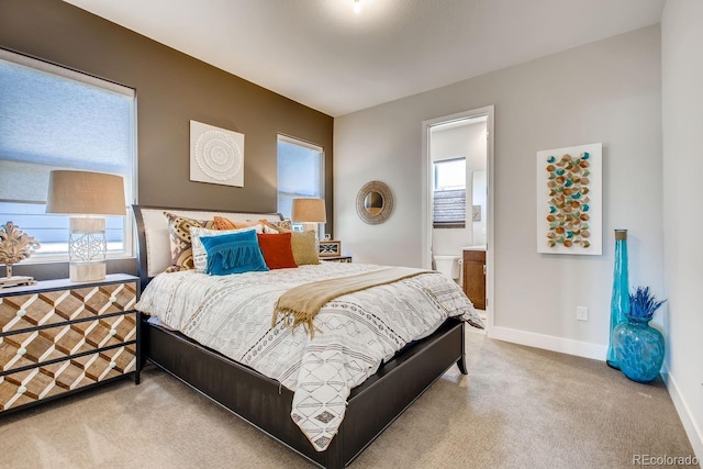 bedroom with carpet, connected bathroom, and multiple windows