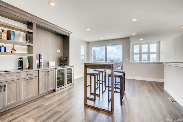 kitchen featuring beverage cooler and light wood-type flooring