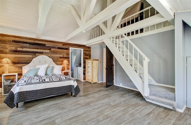 bedroom featuring wood finished floors and wooden walls