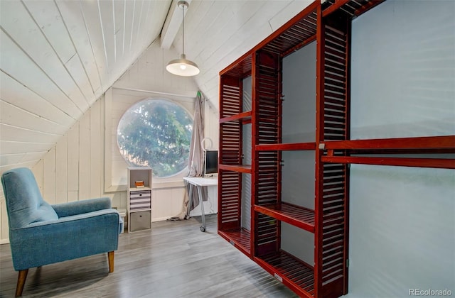 living area with lofted ceiling, wood finished floors, wood walls, and wooden ceiling