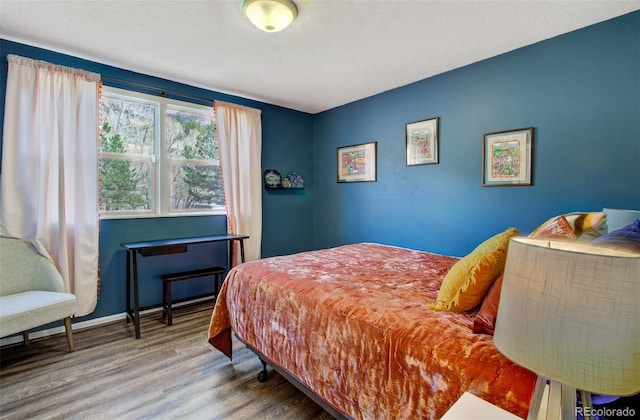 bedroom with wood finished floors and baseboards