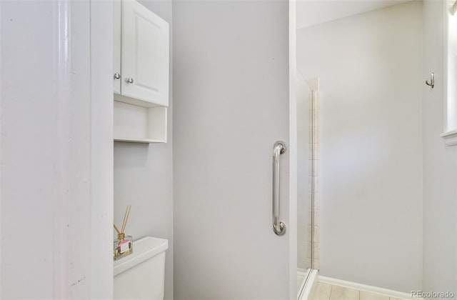 full bath with toilet, a shower, and baseboards