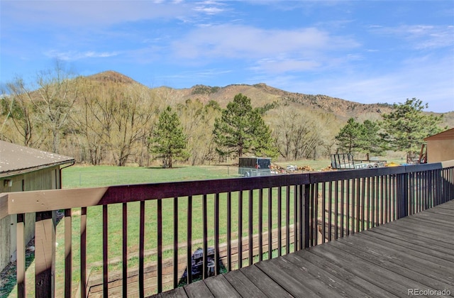 wooden deck featuring a lawn and a mountain view