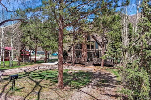 back of property with a deck and a yard