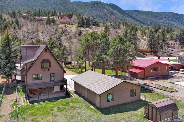 view of subject property with mountains and a heavily wooded area