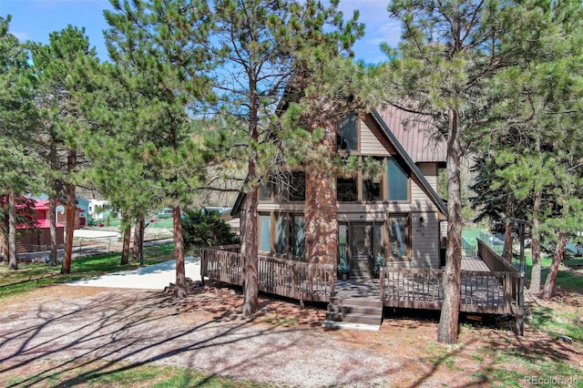 rear view of property with a deck and metal roof