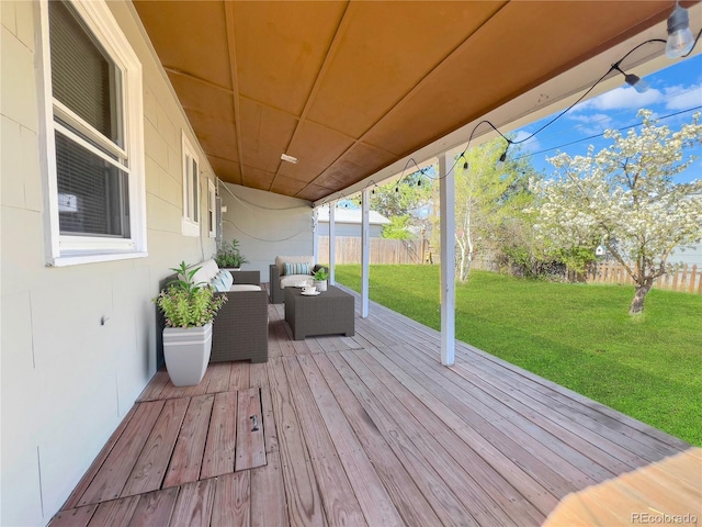 wooden deck featuring fence, a lawn, and an outdoor living space