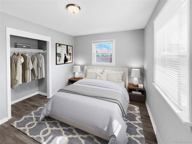 bedroom featuring baseboards, wood finished floors, and a closet