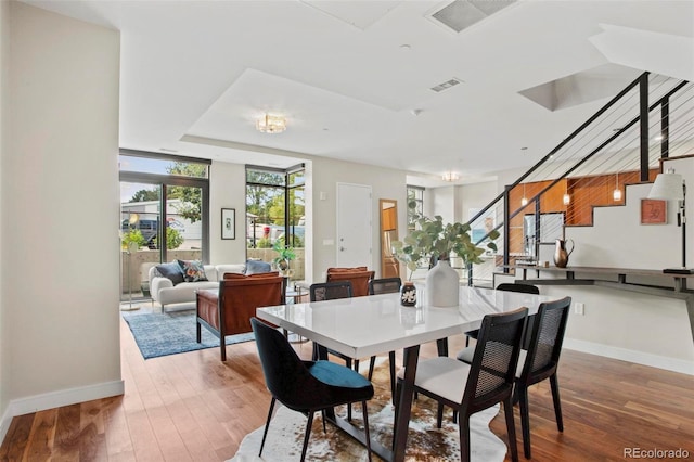 dining area with hardwood / wood-style floors and expansive windows