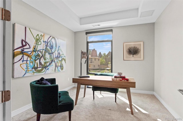 home office featuring a tray ceiling and light colored carpet