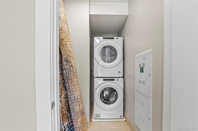 clothes washing area featuring stacked washing maching and dryer